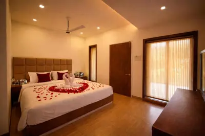 a bedroom with a large bed with a large window at Oxyvalley Resort in Attappādi