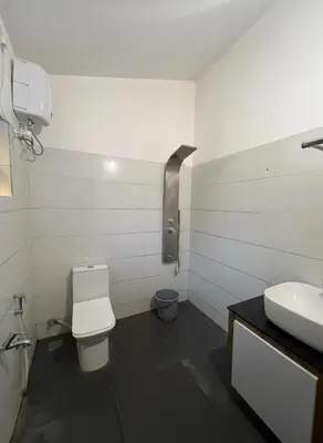 a bathroom with a toilet and a sink at Oxyvalley Resort in Attappādi