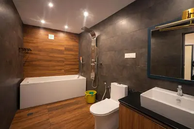 a bathroom with a tub and a toilet and a sink at Oxyvalley Resort in Attappādi