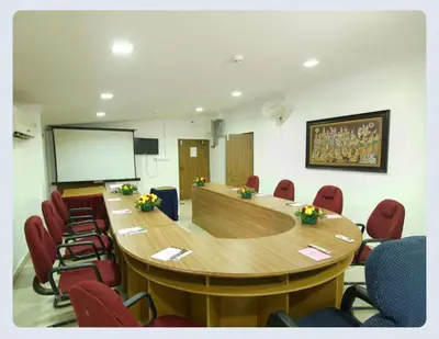 a conference room with a large wooden table and chairs at Hotel Sasthapuri in Kozhikode