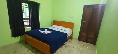 a bedroom with a bed with a white flower on it at Empire HomeStay in Kalpetta