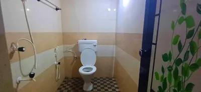 a bathroom with a toilet in a stall at Empire HomeStay in Kalpetta