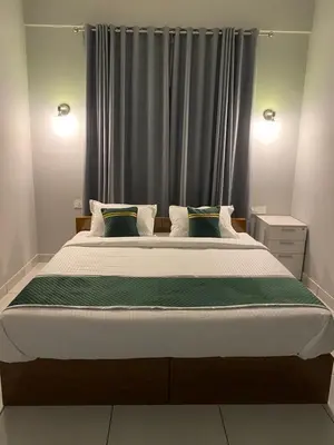 a bedroom with a large bed in front of a window at HOLLYWOOD Rooms in Sultan Bathery
