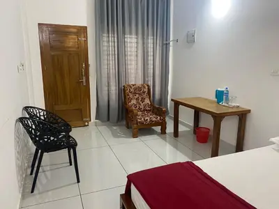 a bedroom with a bed and a table and a chair at HOLLYWOOD Rooms in Sultan Bathery