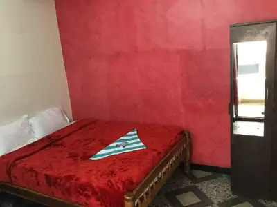 a red bedroom with a bed with a red bedspread at Seven Endue Cottages in Ooty