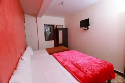 a bedroom with a bed with a red blanket on it at Seven Endue Cottages in Ooty