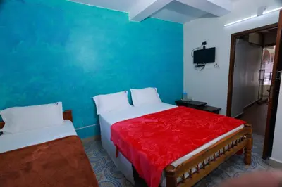 a bedroom with a bed and a blue wall at Seven Endue Cottages in Ooty
