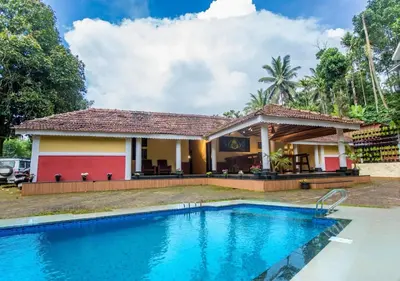 a villa with a swimming pool in front of a house at Chandragiri Heritage Bungalow and Cottages in Vaduvanchal