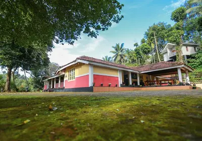 a house with a green field in front of it at Chandragiri Heritage Bungalow and Cottages in Vaduvanchal