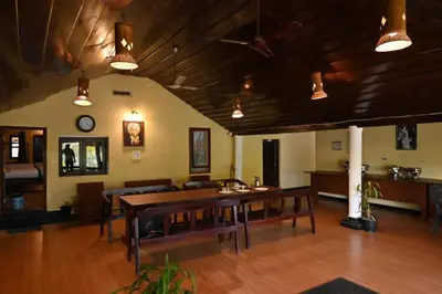 a dining room with a wooden table and chairs at Chandragiri Heritage Bungalow and Cottages in Vaduvanchal