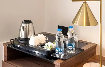 a table with two bottles of water and a lamp at Crystal Suites in Badagara