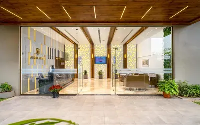 an open lobby with glass doors and a table at Crystal Suites in Badagara