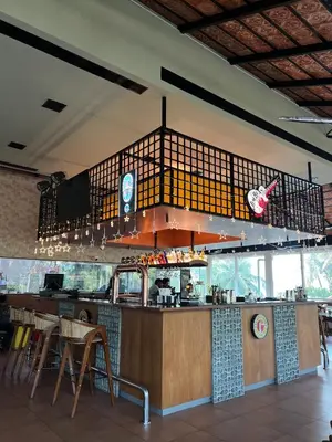 a restaurant with a counter and a bar with chairs at PEARL MAHE in Mahe