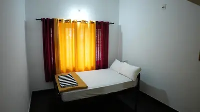 a small bed in a room with a curtain at Thas apartment near rajagiri hospital in Alwaye