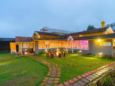 a house with a lawn in front of it at The Hosteller Ooty in Ooty