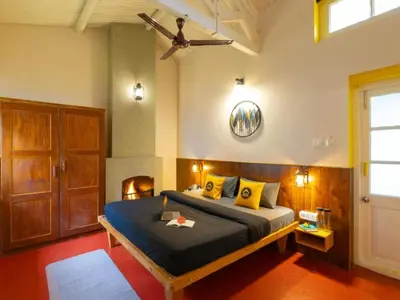 a bedroom with a large bed with yellow pillows at The Hosteller Ooty in Ooty