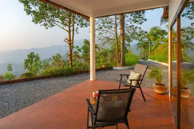 a patio with two chairs and a table at La Grove 2BHK with Stunning View - Kannur in Wayanad