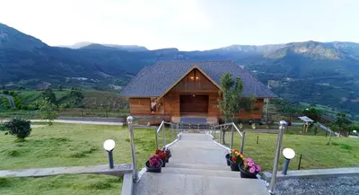 a log cabin with stairs leading to a house at Vrindhavan Farm Suites in Kanthalloor