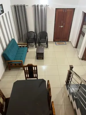 a living room with a blue couch and chairs at HOLLYWOOD Villa in Sultan Bathery