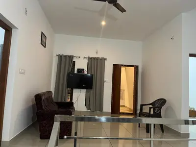 a living room with a glass table and a tv at HOLLYWOOD Villa in Sultan Bathery