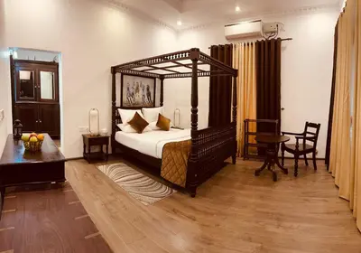 a bedroom with a canopy bed and a table and a desk at CHERAI LAKE RESORT in Cherai Beach