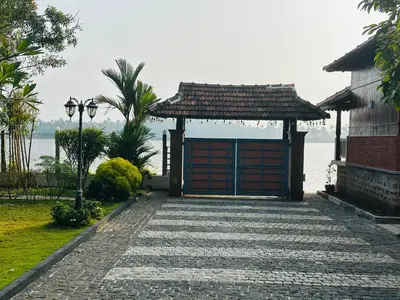 a building with a gate next to the water at CHERAI LAKE RESORT in Cherai Beach