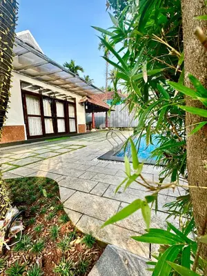a house with a stone walkway and a swimming pool at CHERAI LAKE RESORT in Cherai Beach