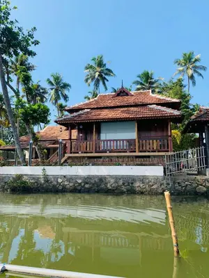 a house next to a body of water at CHERAI LAKE RESORT in Cherai Beach