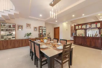 a dining room with a table and chairs at Bask In The Greens Coorg with Private Pool - Pet Friendly - Complimentary Breakfast in Madikeri
