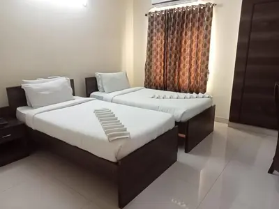 a bedroom with two beds and a window at Chetinaad Courtyard Gandhipuram by Centre Park in Coimbatore