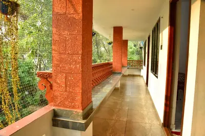 a hallway of a house with red brick walls at Dhakshina Homestay in Cochin