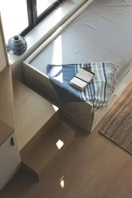 a bedroom with a bed and a window with books on it at The Little Acres Cherai in Vypīn