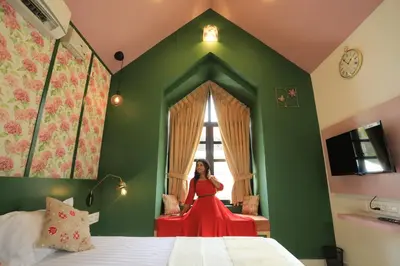 a woman in a red dress sitting in a room at The Little Acres Cherai in Vypīn