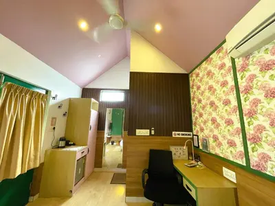 an office with a desk and a room with a kitchen at The Little Acres Cherai in Vypīn