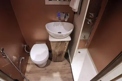 a small bathroom with a toilet and a sink at FRONTLINES CARAVAN in Kadikkād