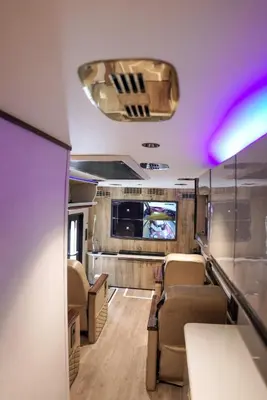a rv with chairs and a tv on the ceiling at FRONTLINES CARAVAN in Kadikkād