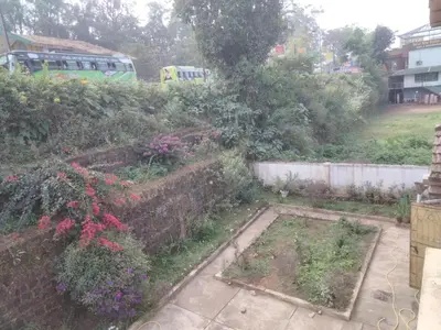 a garden with pink flowers and a fence at Prashanth Family Homestay in Madikeri