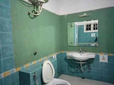 a bathroom with a toilet and a sink at Prashanth Family Homestay in Madikeri