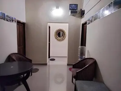 a dining room with a table and chairs and a mirror at Prashanth Family Homestay in Madikeri