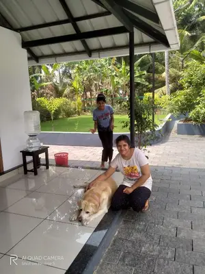 a man sitting on the floor with a dog at EV StayZ in Cherai Beach