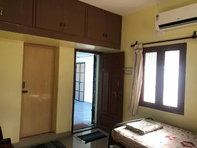 a bedroom with a bed and a window and a door at Single room Homestay Second floor in Palani