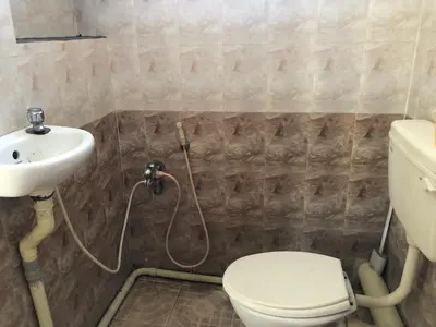 a bathroom with a toilet and a sink at Single room Homestay Second floor in Palani