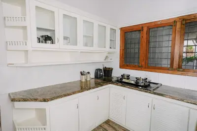a kitchen with white cabinets and a counter top at Alite Posh 4 BHK Villa in Thrissur Town in Trichūr