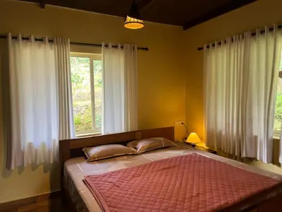 a bedroom with a large bed with a window at Zyamadhari in Mananthavady