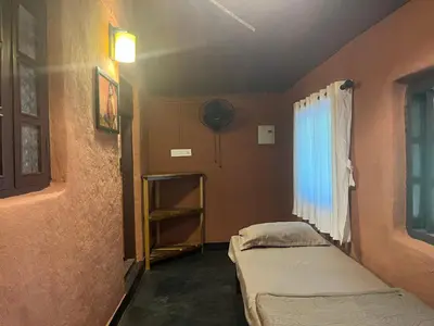 a small room with two beds and a window at Zyamadhari in Mananthavady