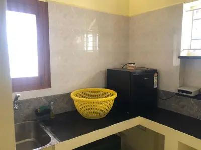 a kitchen with a sink and a basket on the counter at Aishwarya Nivas in Palani