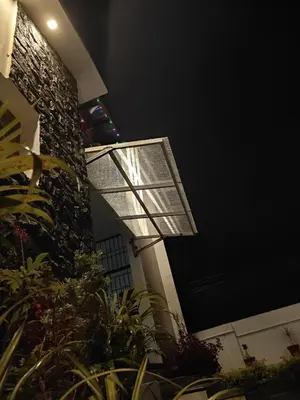 a building with a window and some plants at Kodai Diva Inn - Home Stay in Kodaikānāl