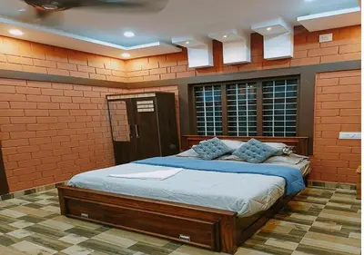 a bedroom with a large bed in a brick wall at Misty Valley Resort in Varagampadi