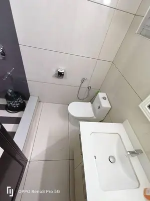 a white bathroom with a toilet and a sink at Peppercorn Cottage, Vythiri. in Vythiri
