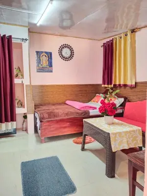 a living room with a bed and a table at AKS Home Stay in Munnar